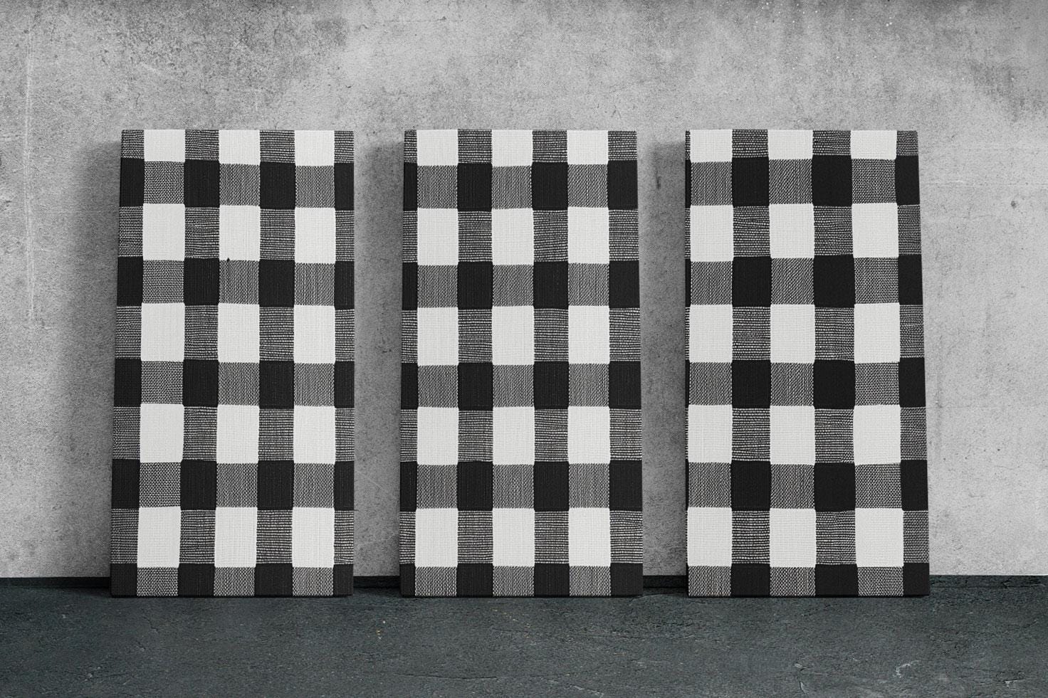three black and white checkered paintings on a wall