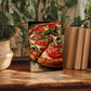 A framed photograph of a pizza with tomato and basil toppings is displayed on a wooden surface, surrounded by potted plants and books.