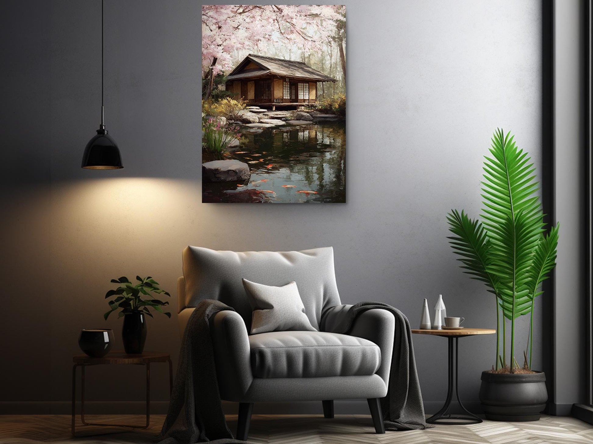 a serene living room with a cozy gray armchair, a wooden side table, and a potted plant. Above the armchair, there is a framed painting of a tranquil Japanese garden with a small wooden house and a pond.