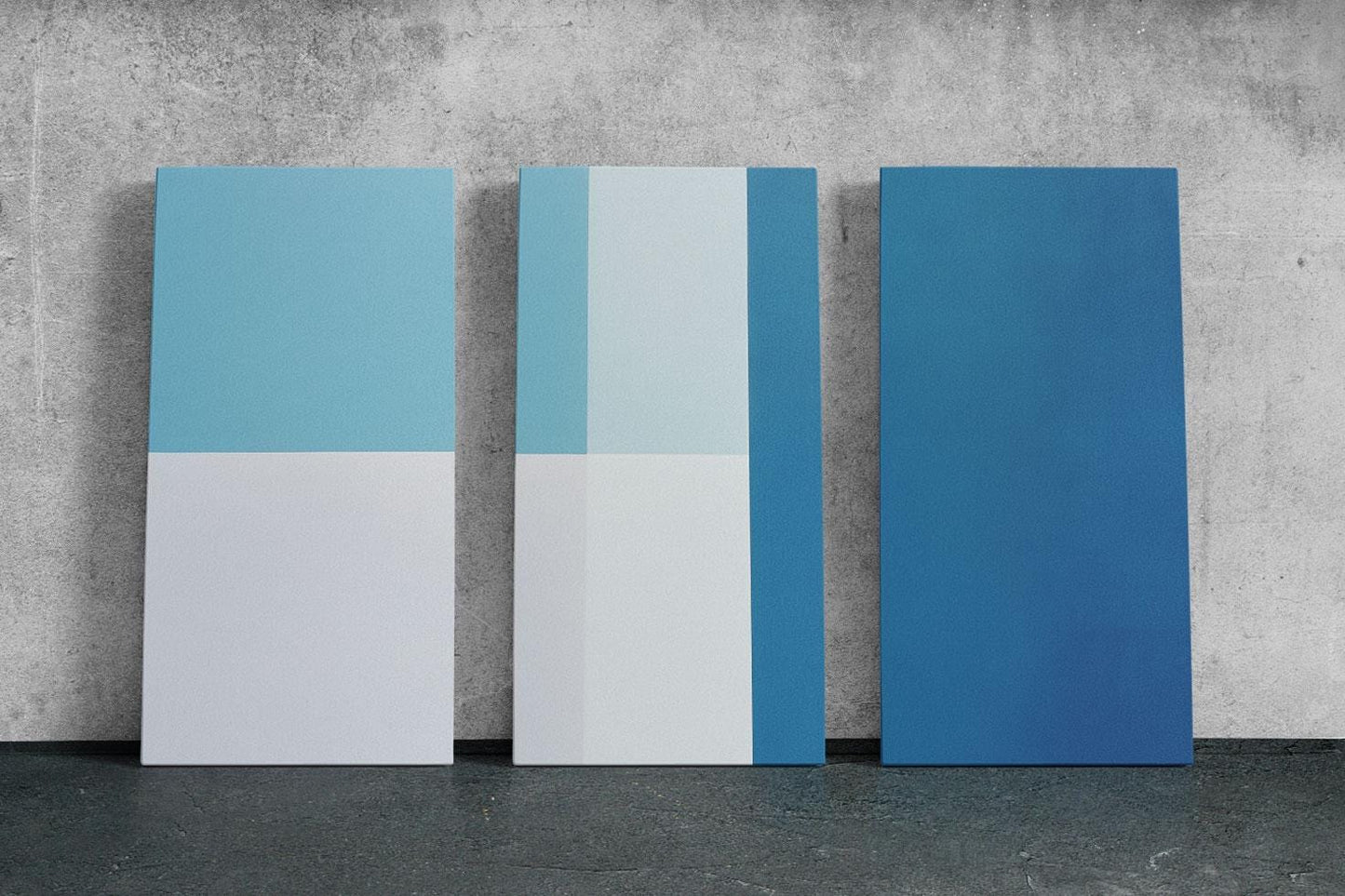 three blue and white pieces of art against a concrete wall