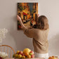 A woman hangs a painting of a city street scene on a wall in a cozy, homely setting.