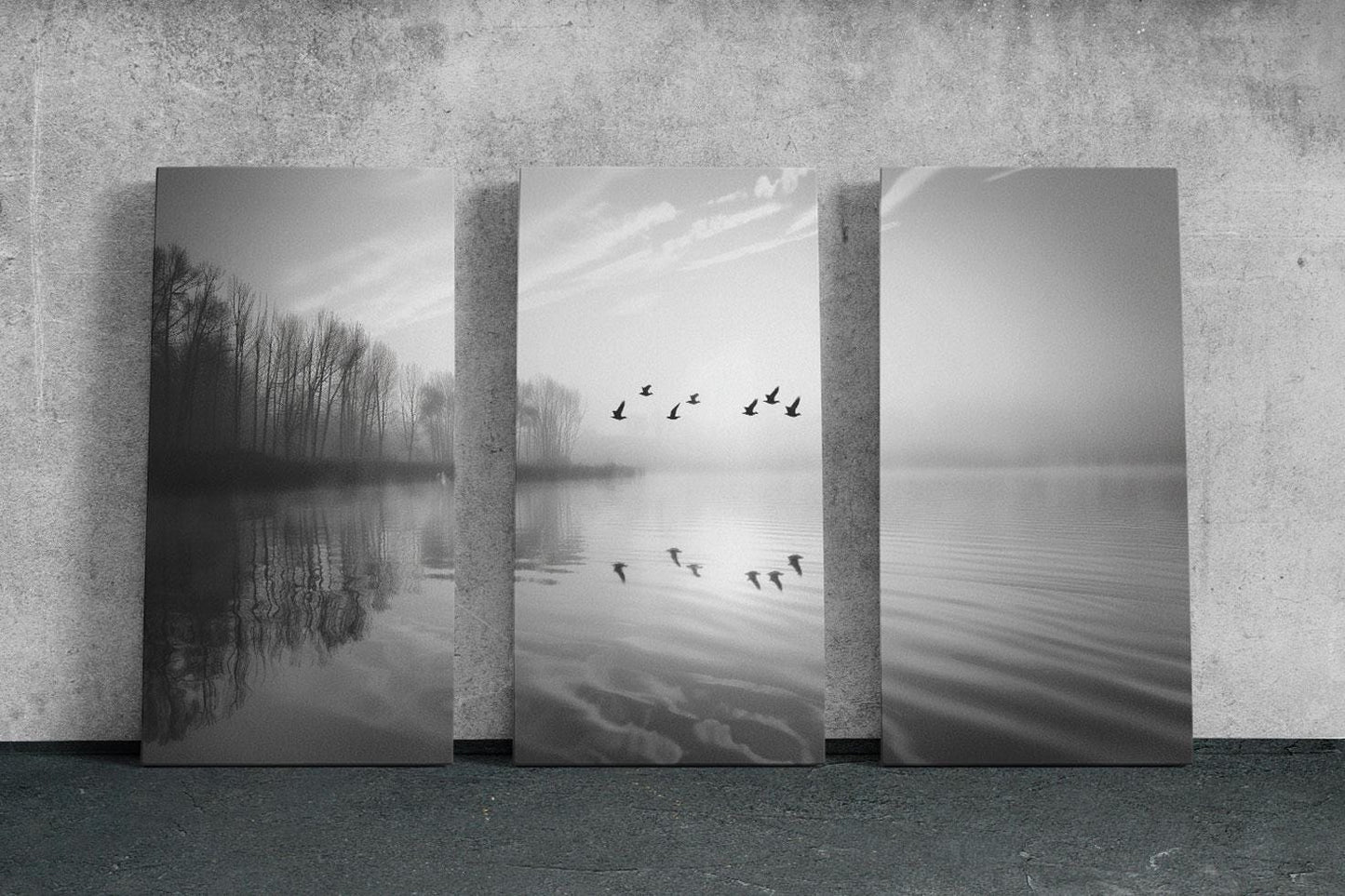 a black and white photo of birds flying over a lake
