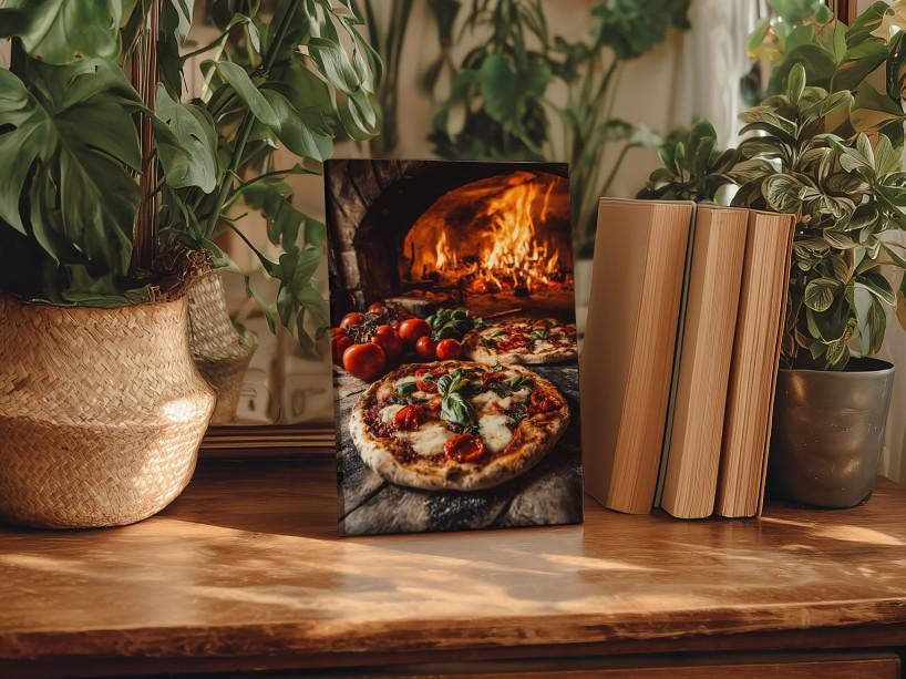 A framed photograph of a pizza with tomatoes and basil is displayed on a wooden table, surrounded by potted plants and books.