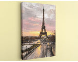 the Eiffel Tower in Paris, France, with a colorful sunset sky in the background.