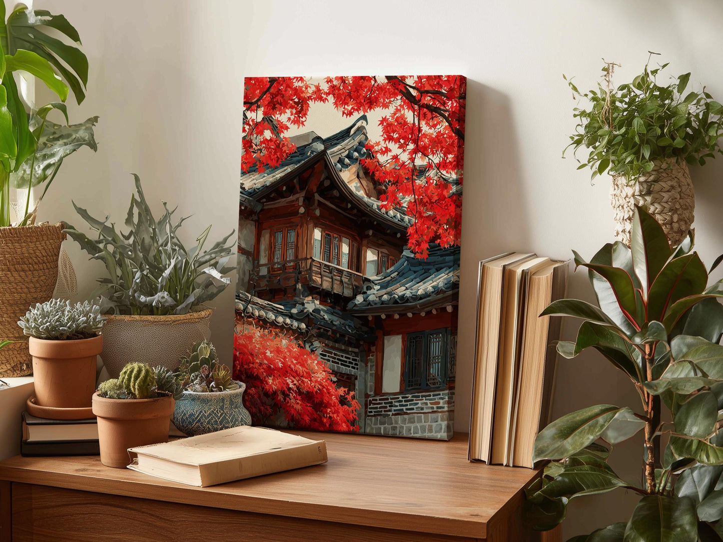 a wooden desk with a framed picture of a traditional Korean temple, surrounded by various potted plants and books.