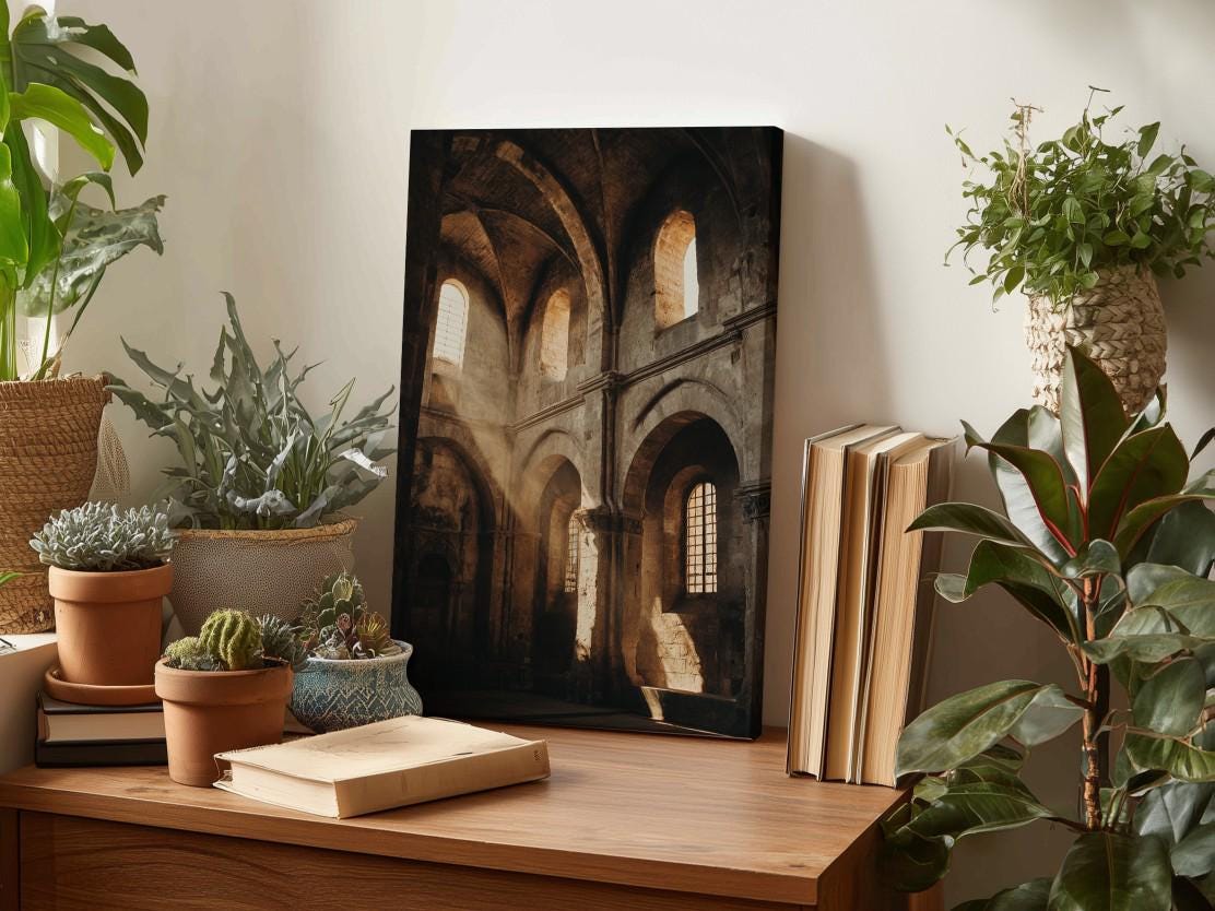 a wooden desk with a framed photograph of an old building, surrounded by various potted plants and books.