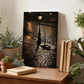 a wooden table with a framed photograph of a cobblestone street at night, surrounded by potted plants and books.