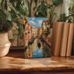 a painting of a canal scene with a gondola, surrounded by lush green plants and placed on a wooden surface.
