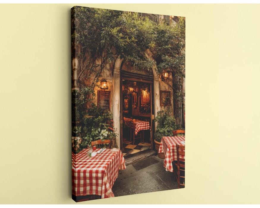 a cozy outdoor dining area with red and white checkered tablecloths, surrounded by lush greenery and a rustic stone wall.