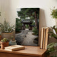 a serene Japanese garden scene, with a traditional wooden gate and a stone path leading to a small pond. The garden is surrounded by lush greenery, including various potted plants and trees. A bookshelf with books and a vase of flowers can be seen in the foreground, creating a cozy and tranquil atmosphere.