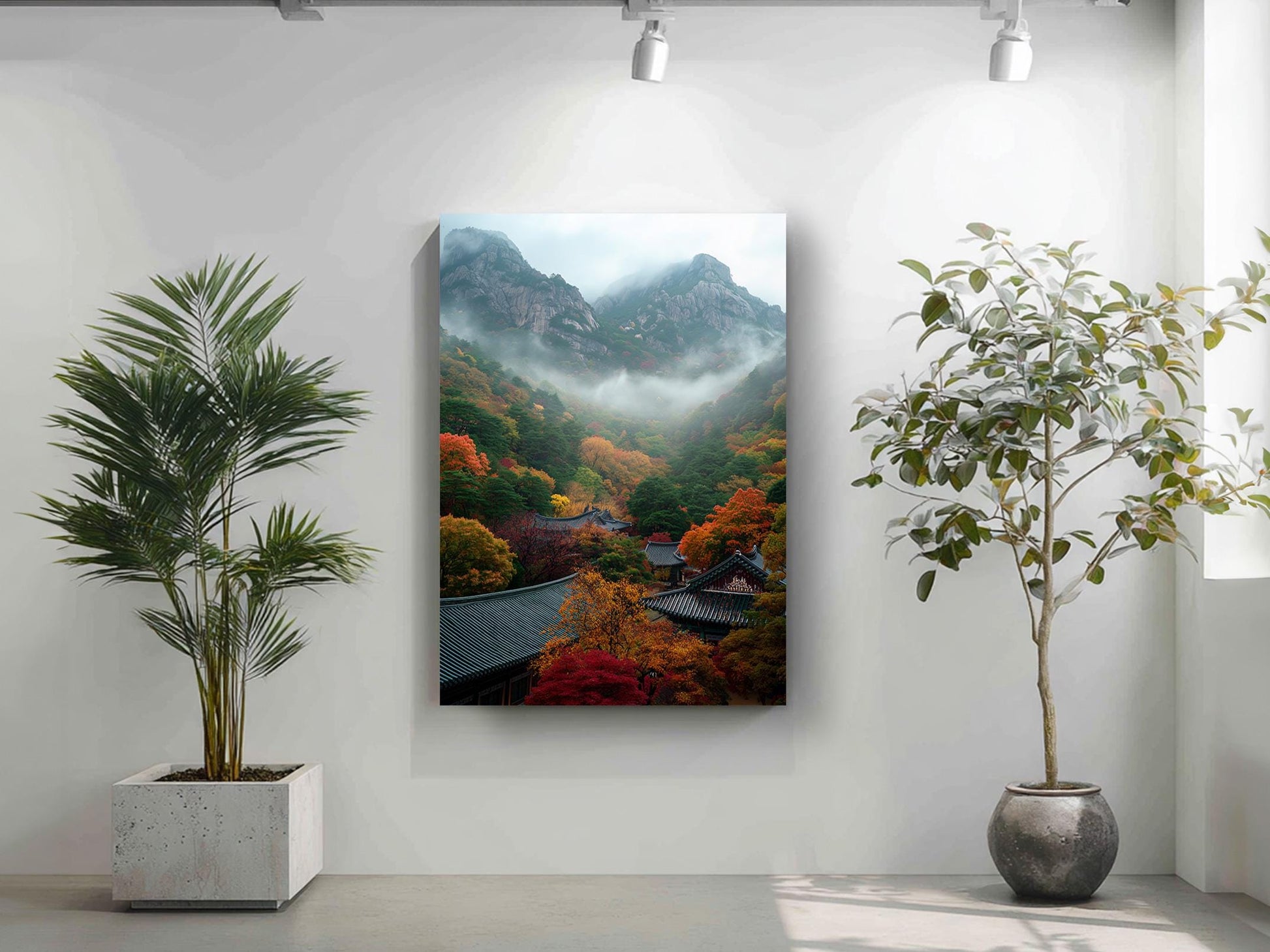 a serene indoor setting with a large painting of a mountainous landscape hanging on the wall, flanked by two potted plants.