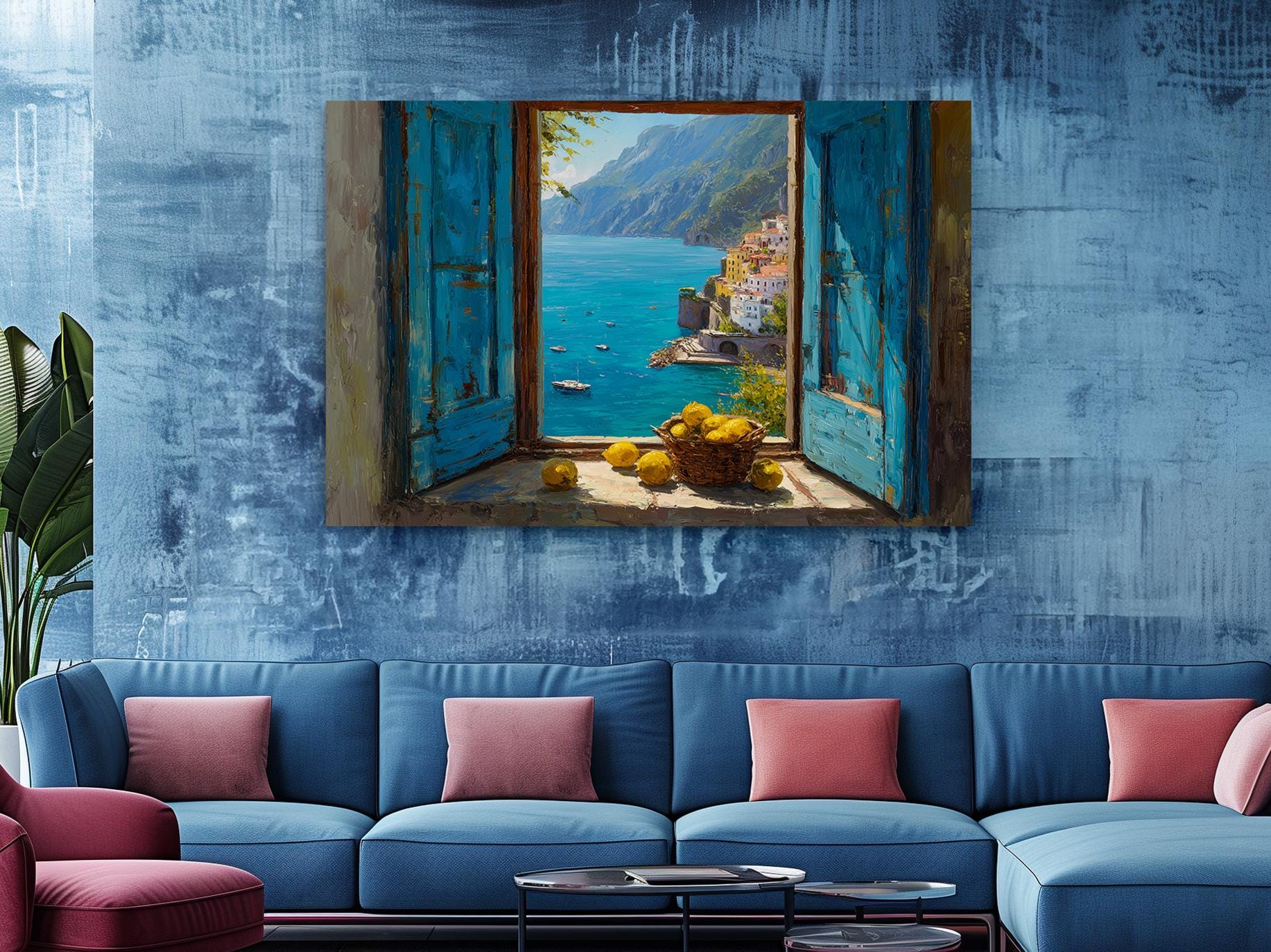 a blue sofa with pink pillows, a large painting of a coastal town with a window overlooking the sea, and a plant in the corner.