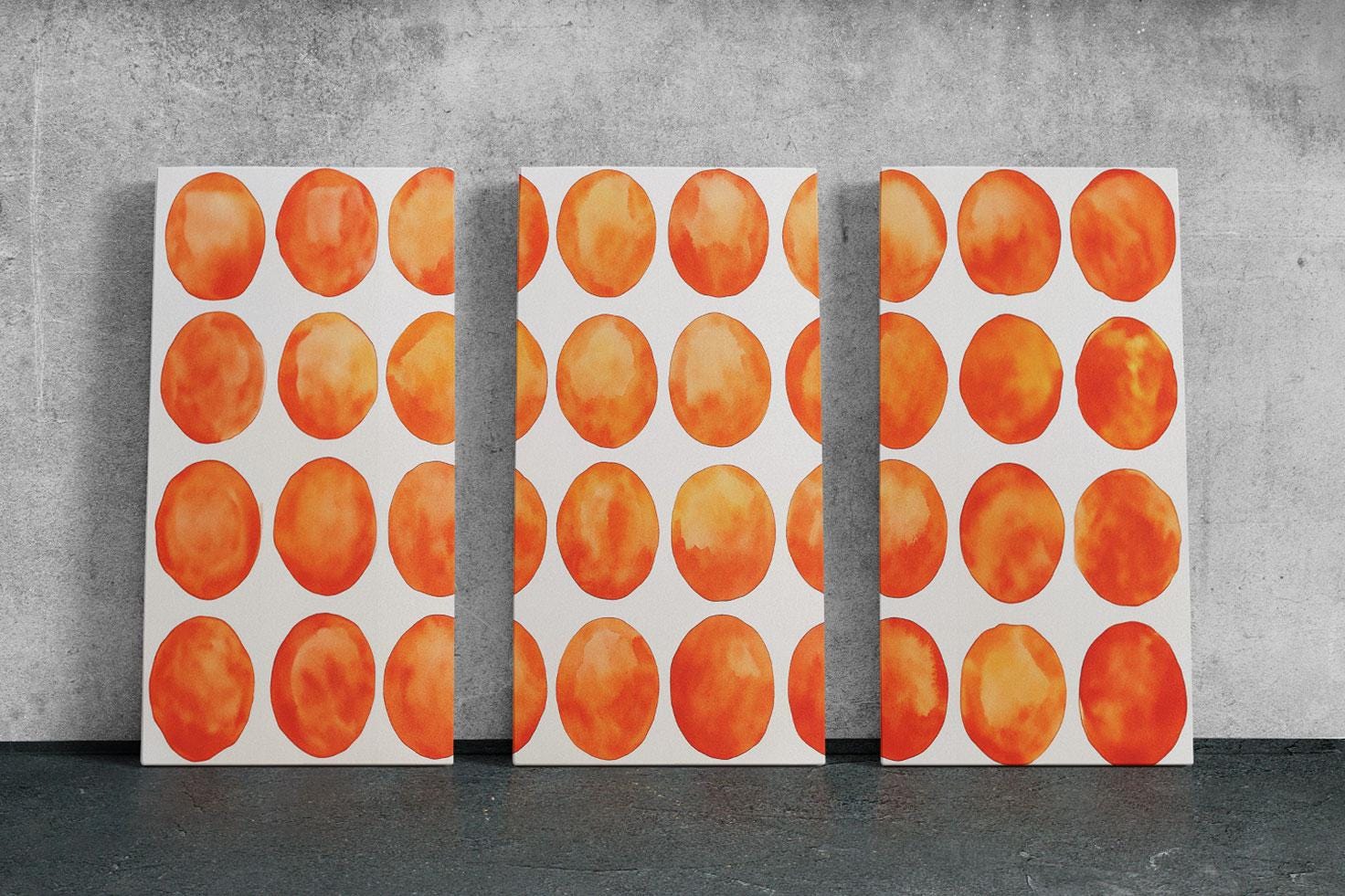 three paintings of orange circles on a white wall