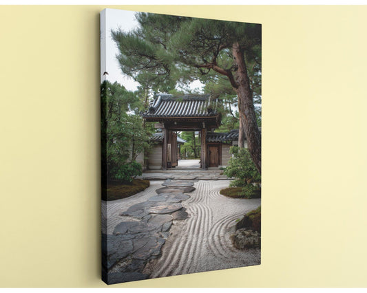 A traditional Japanese temple gate surrounded by a serene garden with a stone path leading up to it.