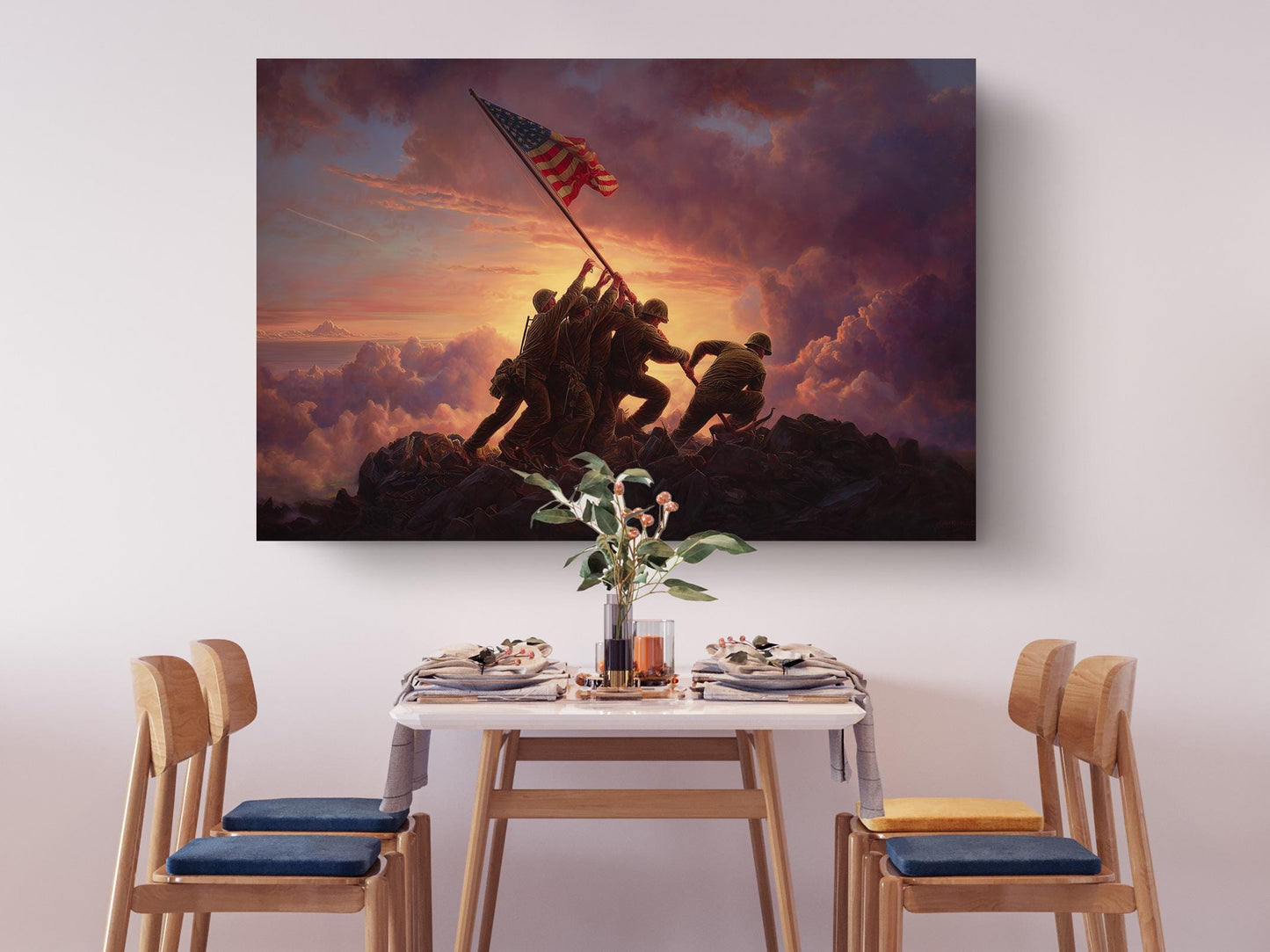a dining table set with plates, silverware, and a vase of flowers, with a large painting of soldiers on a mountain in the background.