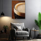 a cozy living room with a comfortable gray armchair, a wooden side table, and a potted plant. Above the armchair, there is a framed photograph of a glass of beer with a frothy head, creating a warm and inviting atmosphere.
