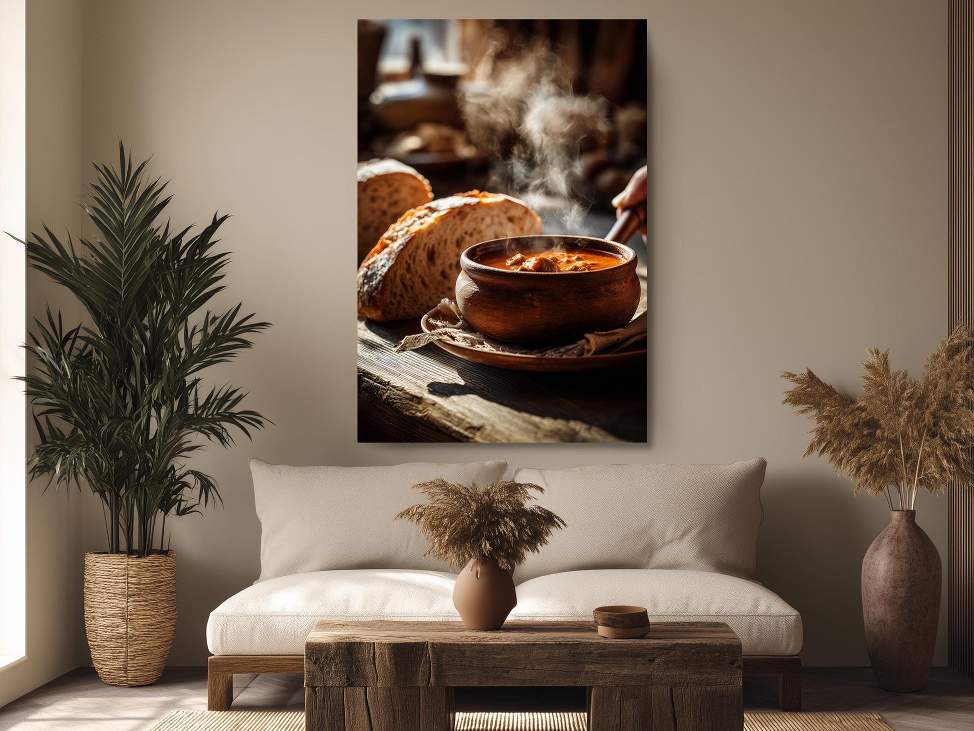 a cozy living room with a large wooden coffee table in the center, surrounded by a white sofa and a potted plant. Above the sofa, there is a framed photograph of a bowl of soup on a wooden surface, with steam rising from it.