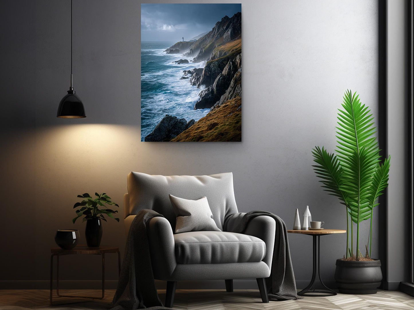 a living room with a gray armchair, a potted plant, and a framed photograph of a cliff overlooking the ocean.