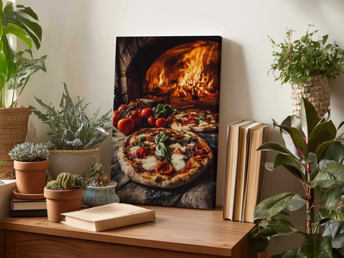 a wooden table with a framed photograph of a pizza in a brick oven, surrounded by potted plants and books.