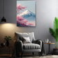 a serene living room with a gray armchair, a potted plant, and a framed picture of a mountain with pink blossoms hanging on the wall.